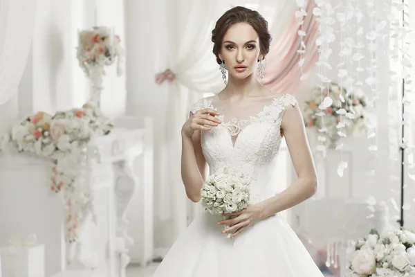 The beautiful woman posing in a wedding dress — Stok fotoğraf