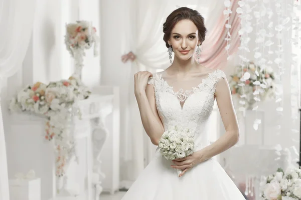 The beautiful woman posing in a wedding dress — Stock Photo, Image