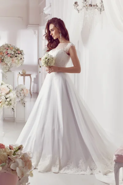 The beautiful woman posing in a wedding dress — Stock Photo, Image