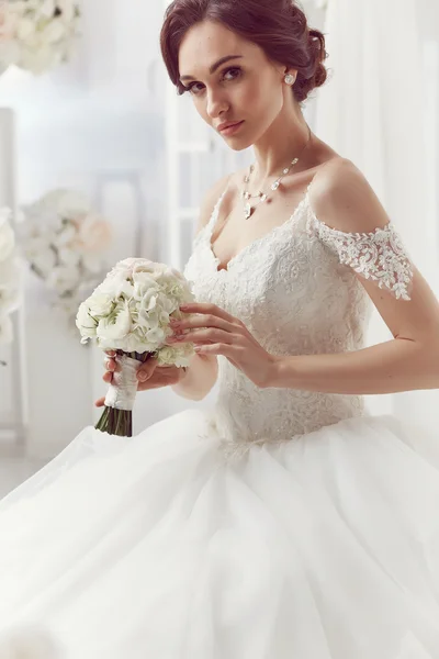 La bella donna in posa in un abito da sposa — Foto Stock