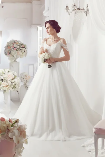 The beautiful woman posing in a wedding dress — Stock Photo, Image