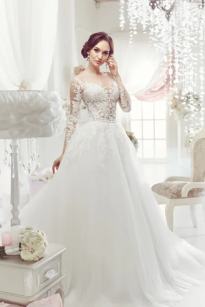 The beautiful woman posing in a wedding dress — Stock Photo, Image