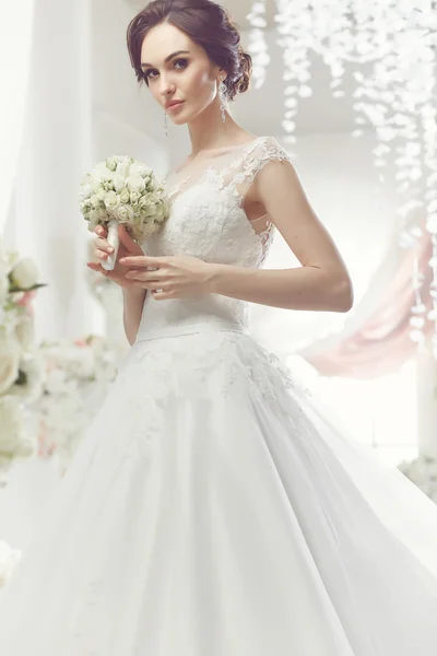 The beautiful woman posing in a wedding dress — Stock Photo, Image