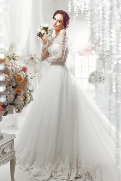 The beautiful woman posing in a wedding dress — Stock Photo, Image