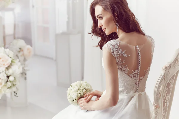 Die schöne Frau posiert im Hochzeitskleid lizenzfreie Stockfotos