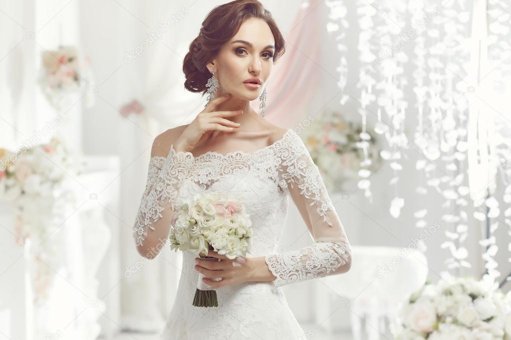 The beautiful woman posing in a wedding dress