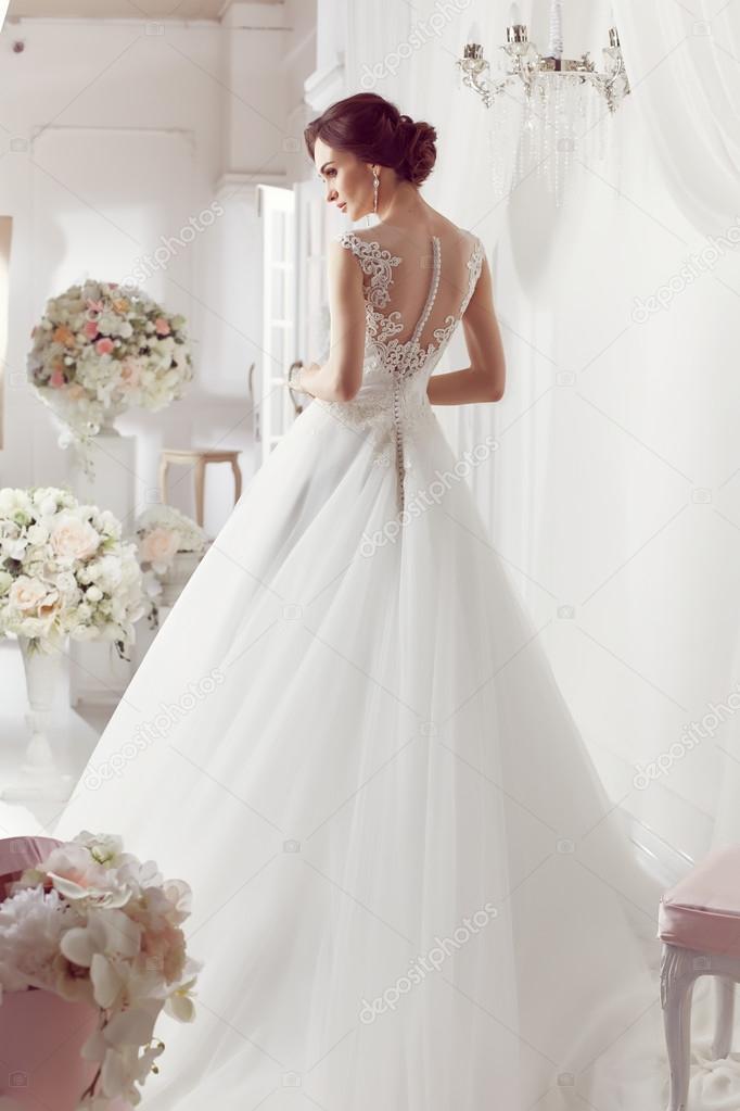 The beautiful woman posing in a wedding dress