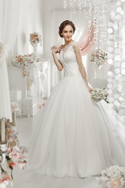 The beautiful woman posing in a wedding dress