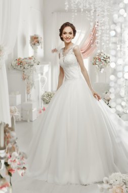 The beautiful woman posing in a wedding dress