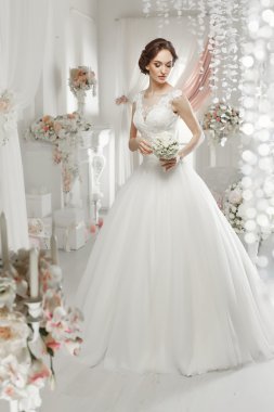 The beautiful woman posing in a wedding dress