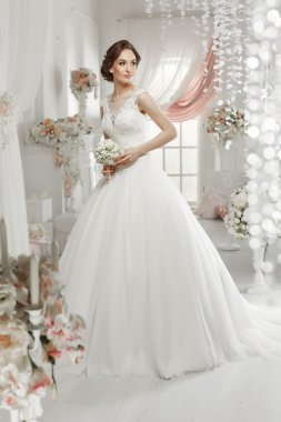 The beautiful woman posing in a wedding dress