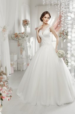 The beautiful woman posing in a wedding dress