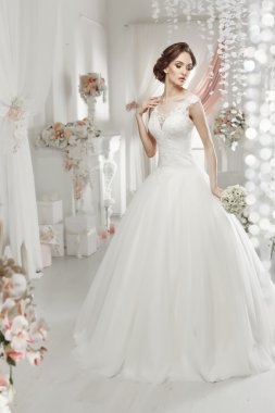 The beautiful woman posing in a wedding dress