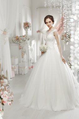 The beautiful woman posing in a wedding dress