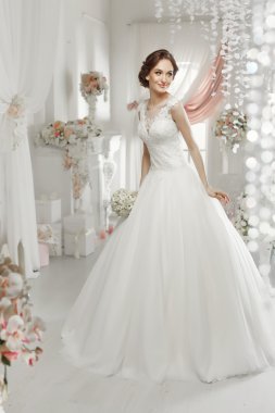 The beautiful woman posing in a wedding dress