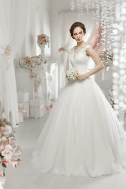 The beautiful woman posing in a wedding dress