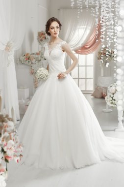 The beautiful woman posing in a wedding dress
