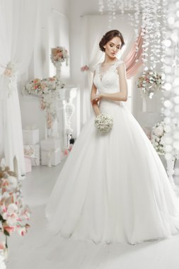 The beautiful woman posing in a wedding dress