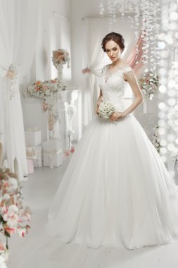 The beautiful woman posing in a wedding dress