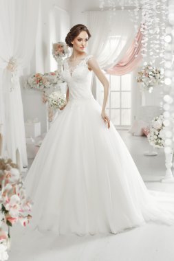 The beautiful woman posing in a wedding dress