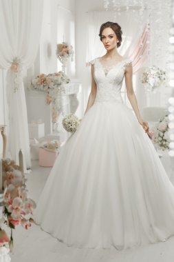 The beautiful woman posing in a wedding dress