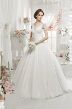 The beautiful woman posing in a wedding dress