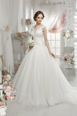 The beautiful woman posing in a wedding dress