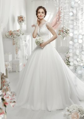 The beautiful woman posing in a wedding dress