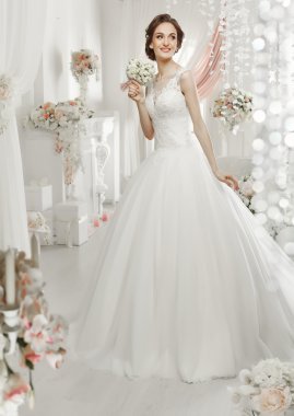 The beautiful woman posing in a wedding dress