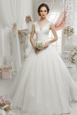 The beautiful woman posing in a wedding dress