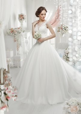 The beautiful woman posing in a wedding dress