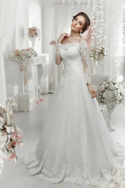 The beautiful woman posing in a wedding dress — Stock Photo, Image