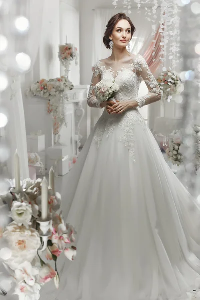 Die schöne Frau posiert im Hochzeitskleid — Stockfoto