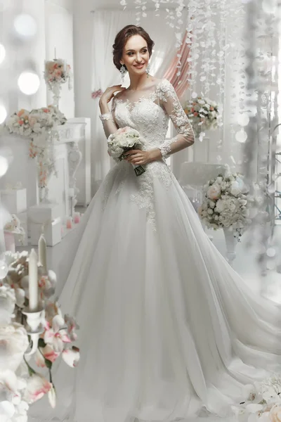 The beautiful woman posing in a wedding dress — Stock Photo, Image