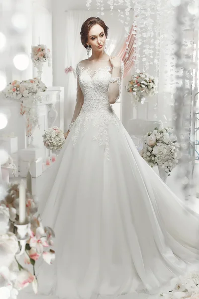 The beautiful woman posing in a wedding dress — Stock Photo, Image