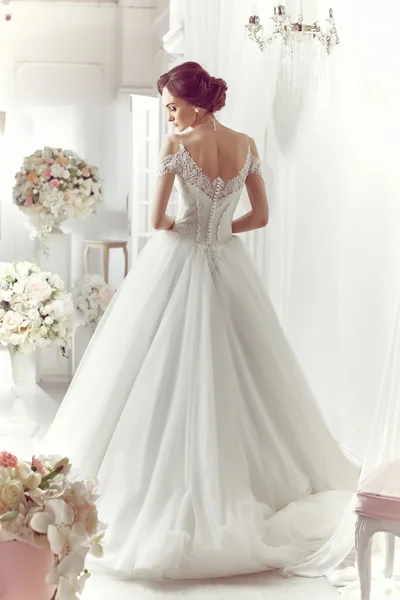 The beautiful woman posing in a wedding dress — Stok fotoğraf