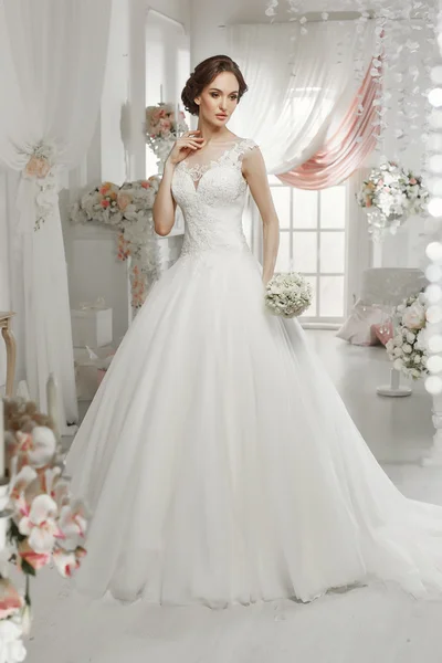 The beautiful woman posing in a wedding dress — Stock Photo, Image