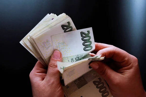 Siyah arka planda para tutan bir kadın. 2000 banknot.