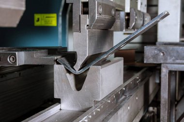 Hidrolik bükme makinesindeki metal levha bükme işlemi. Metal fabrikası.