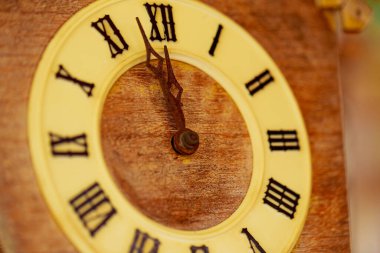 Saat, Roma rakamlı guguklu retro saati gösteriyor. Yakında saat yüzünde 12 kilitlenme olacak. Kapat..
