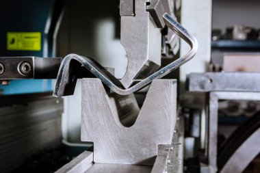Hidrolik bükme makinesindeki metal levha bükme işlemi. Metal fabrikası.