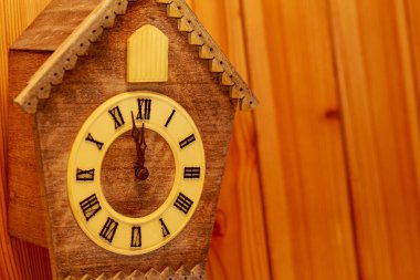 Tahta duvarında Roma rakamları olan guguklu saat. Uzayı kopyala Yeni Yıl.