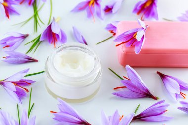 Beyaz arka planda safran çiçekleri ve safran sabunlu kozmetik krem..