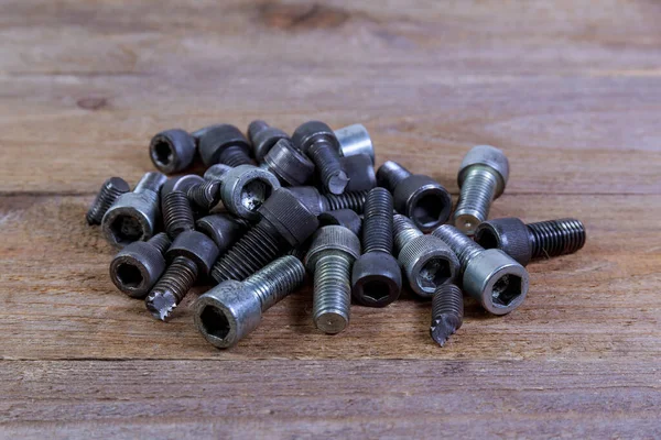 Perno negro roto aislado sobre fondo de madera. — Foto de Stock