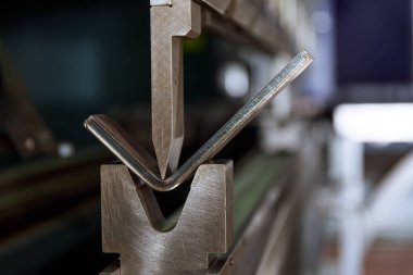 CNC bükme makinesinde metal bükme işlemi. V şeklinde bir matris ve yumruk kullanarak metalin bükülmesi.
