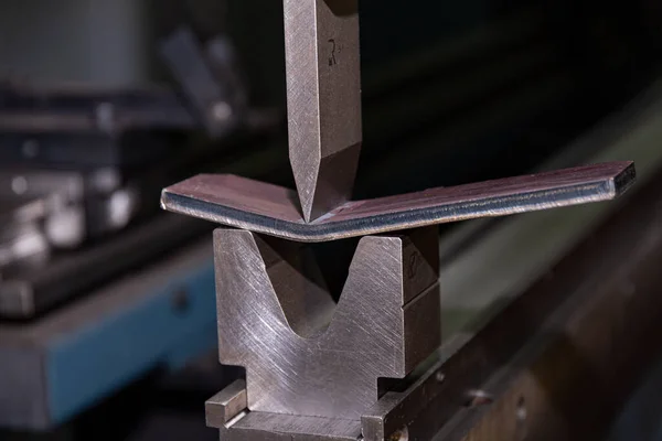 The process of metal bending on a CNC bending machine. Bending of metal using a v-shaped matrix and a punch.