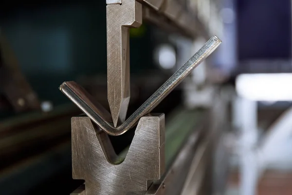 O processo de dobra de metal em uma máquina de dobra CNC. Flexão de metal usando uma matriz em forma de v e um soco. — Fotografia de Stock