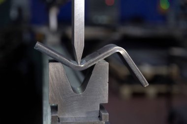 Fabrikadaki hidrolik bir makinede metal bükme levhası. Aletleri bük, frene bas, bas ve öl. Yakın plan..