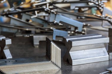 Bükme makinesinde işlem yaptıktan sonra metal levha ürünü. İnşaat için metalden bağlanma üretimi.