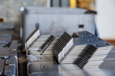 Ürünler bükme makinesine bağlı, yakın plan. Fabrika yapımı metal parçalar..